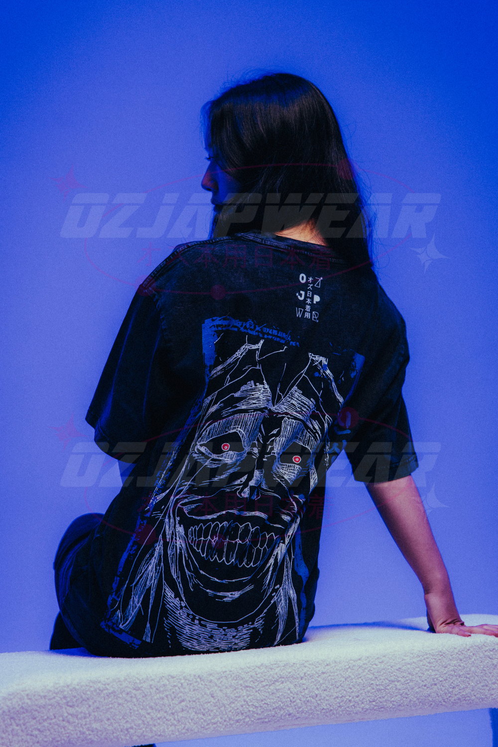 Girl wearing black oversized anime shirt with a creepy skull design under blue lighting, shown from the back.