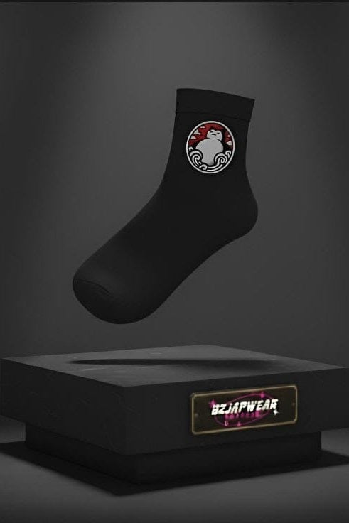 Black anime-themed socks with an embroidered Snorlax-style patch displayed above a black OzJapwear box.