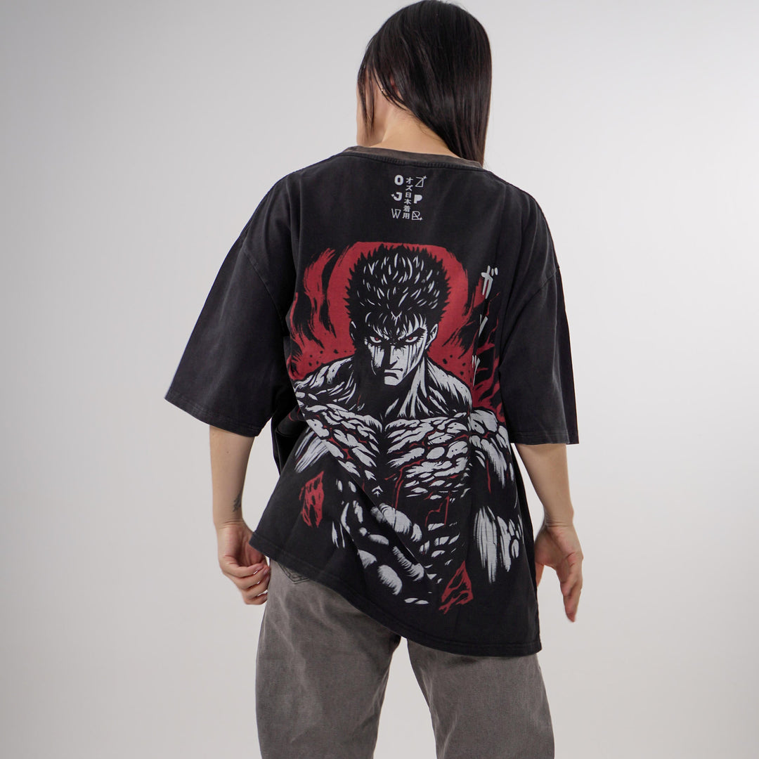 Model showcasing the Guts Berserk Oversized Tee featuring a small front chest print and a large detailed back design of Guts in rage mode, with red and black accents on a heavyweight black cotton shirt.