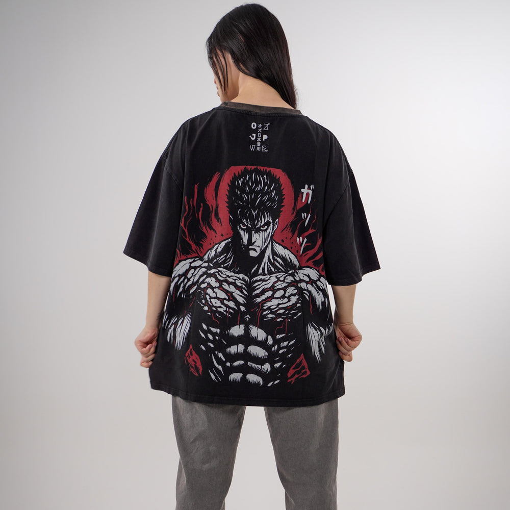 Model showcasing the Guts Berserk Oversized Tee featuring a small front chest print and a large detailed back design of Guts in rage mode, with red and black accents on a heavyweight black cotton shirt.
